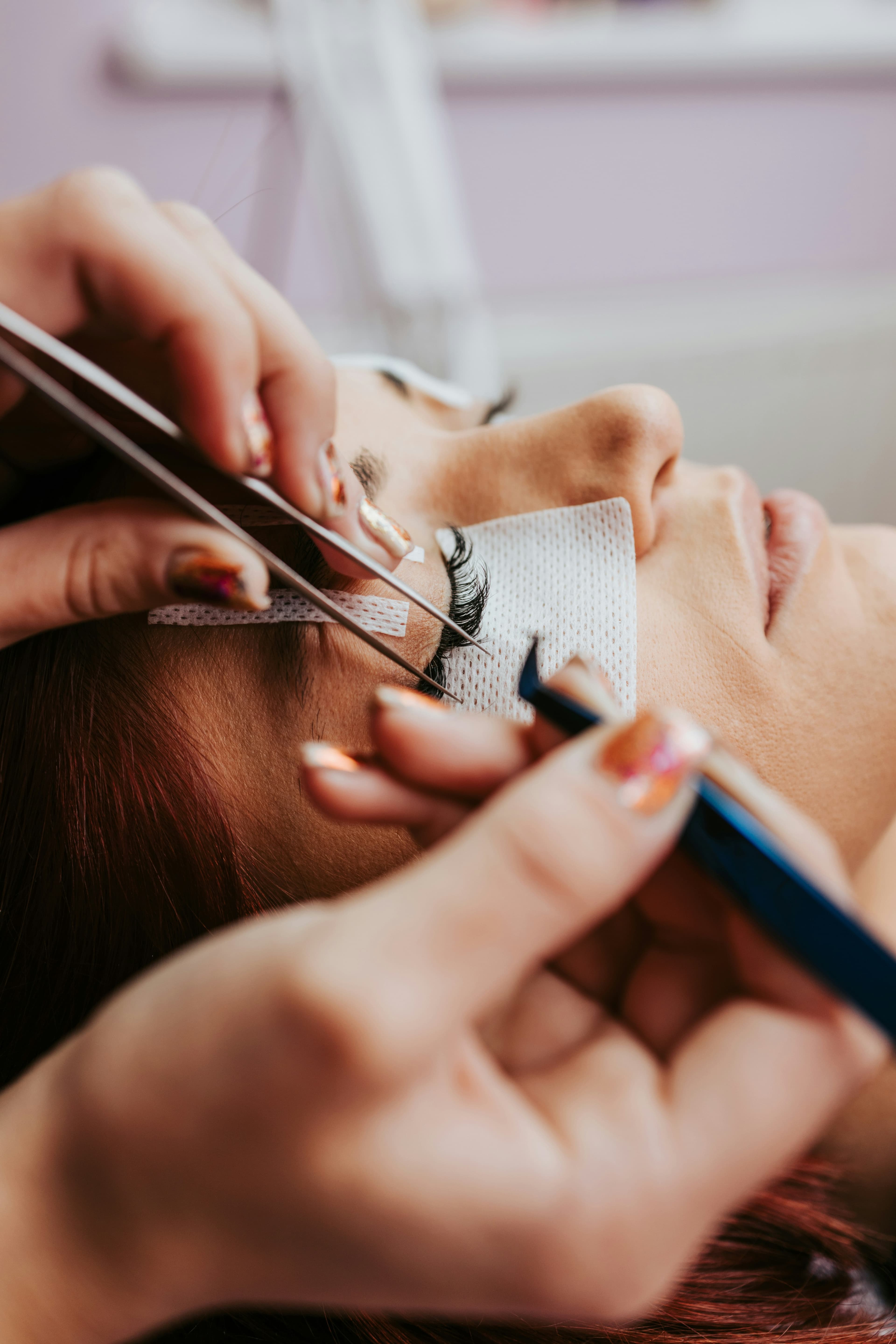 Lash artist carefully applying extensions to a client