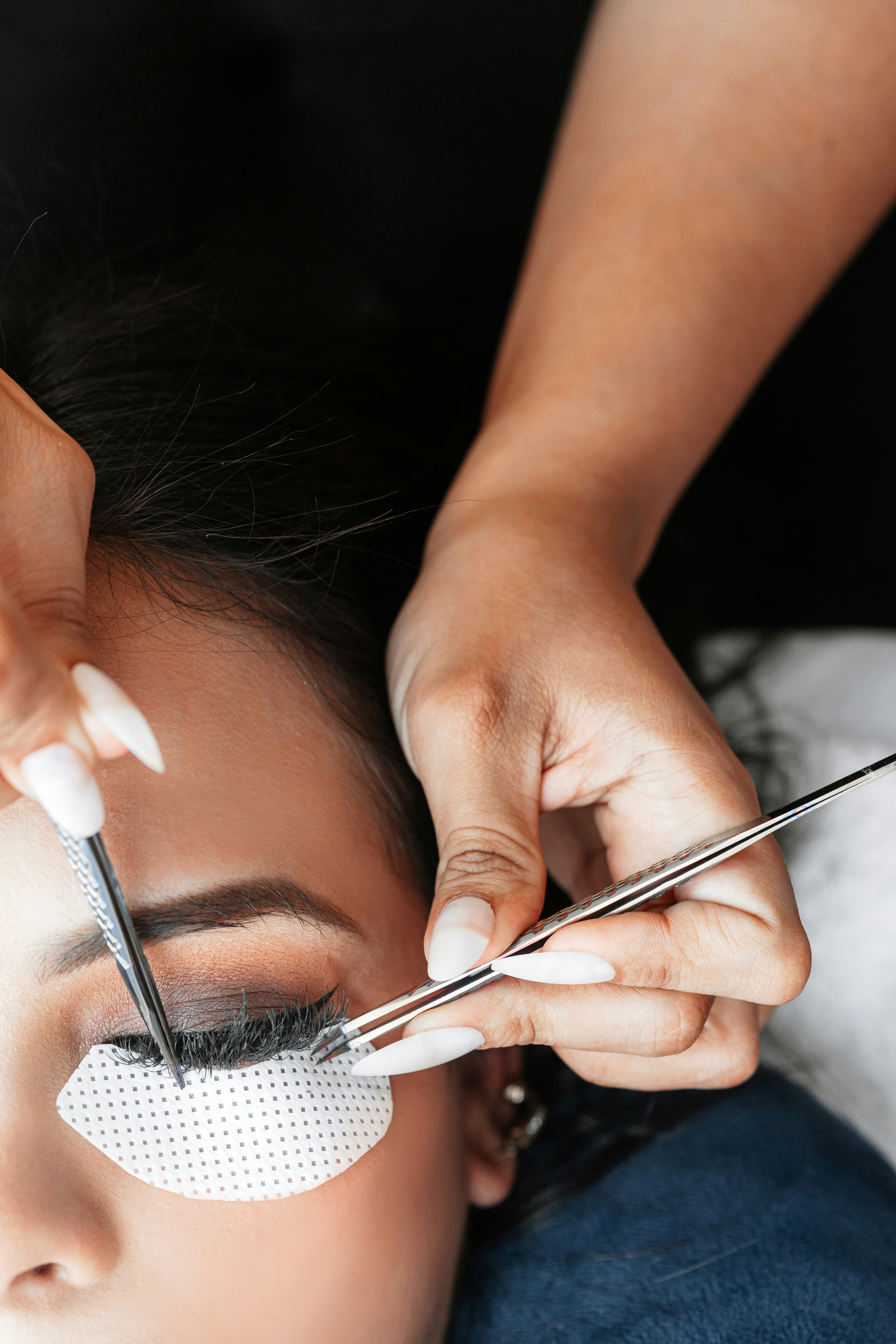 Lash artist applying extensions at The Extensionist