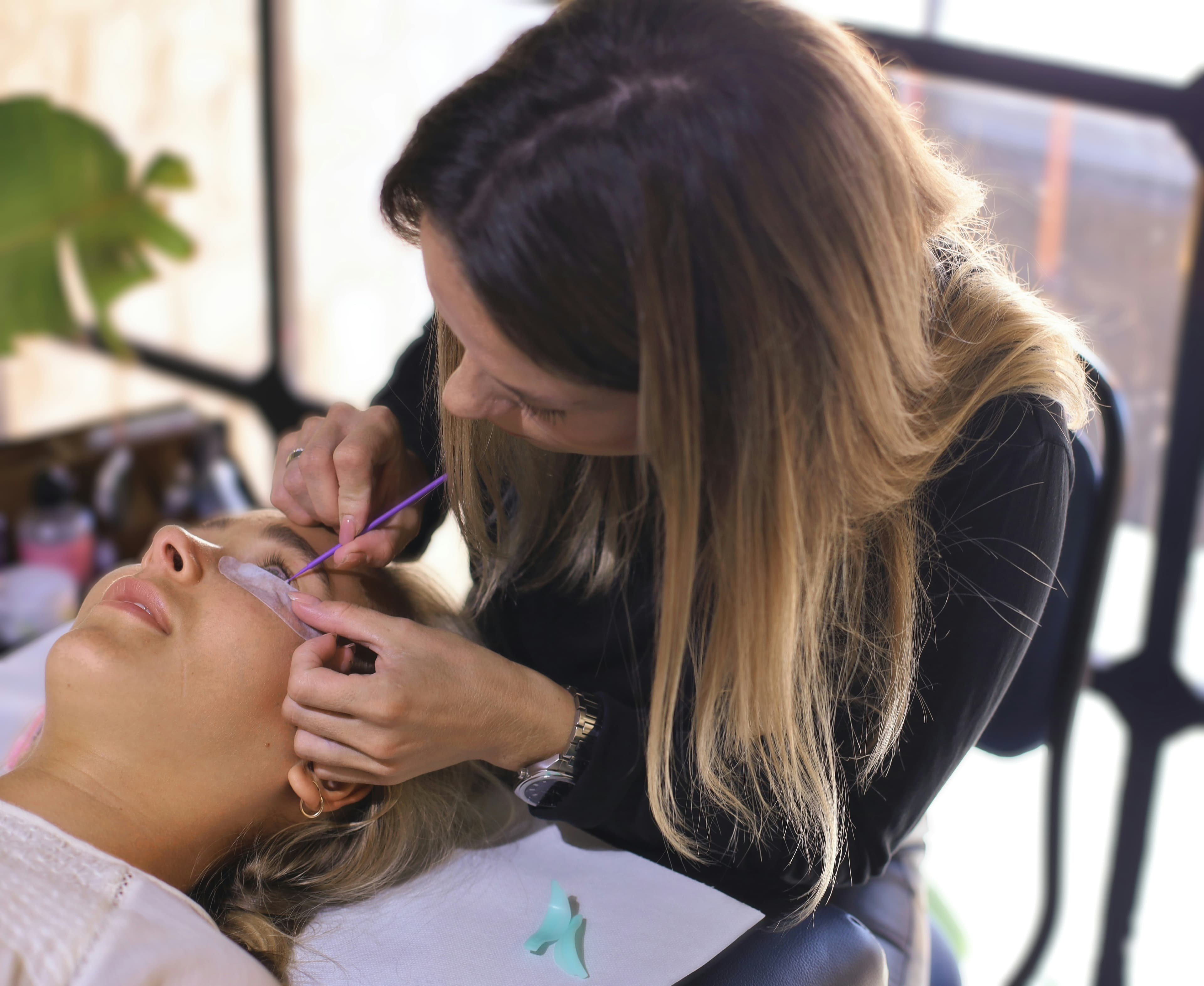 Lash artist working on a client at The Extensionist
